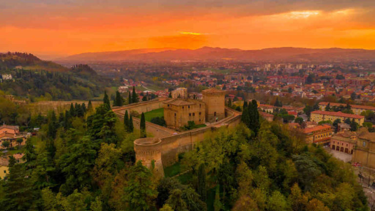 Sunset aerial panorama of Cesena in Emilia Romagna Italy near Forli and Rimini, with the medieval Malatestiana castle, Piazza del Popolo and Roman Catholic churches and cathedral on a winter afternoon